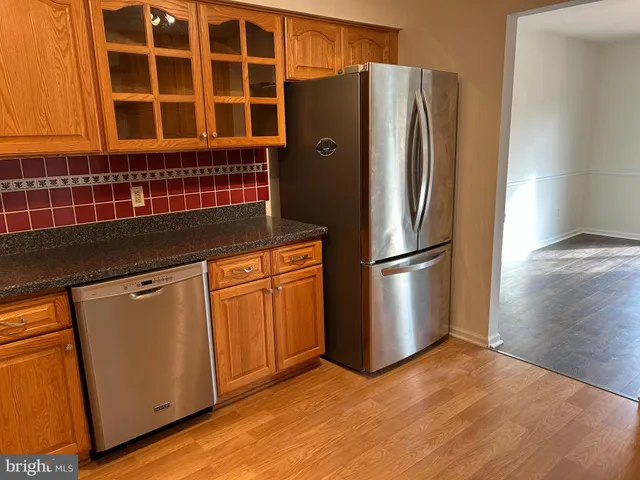 a kitchen with stainless steel appliances granite countertop a refrigerator and a sink