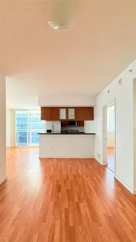a view of a kitchen with a stove wooden cabinets and a refrigerator