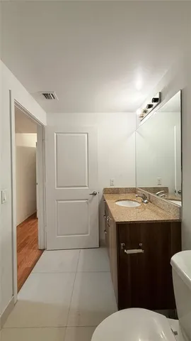 a view of an empty room with wooden floor and window