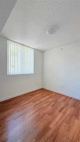 a view of an empty room and wooden floor