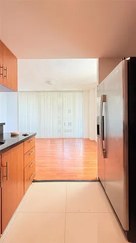 a view of a room that has a large window and a wooden floor