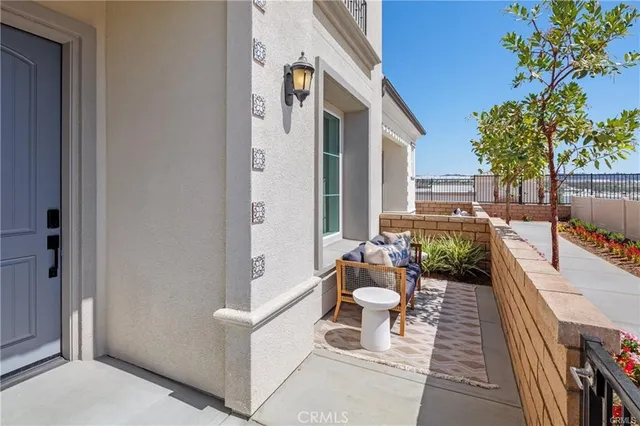 a balcony with chairs and with potted plants