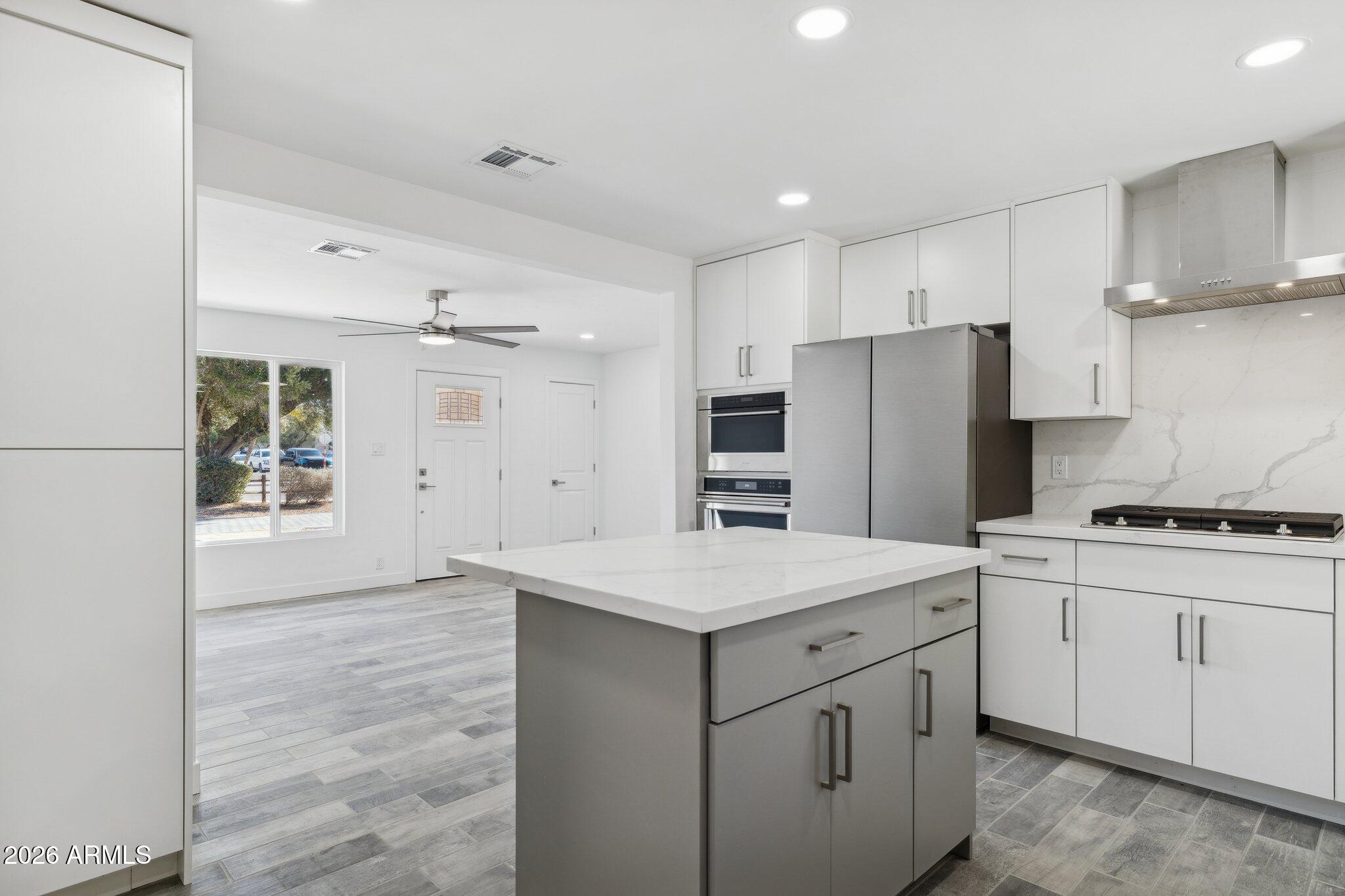 4144 North 36th Street Phoenix, AZ 85018 - Photo 1 of 30 a kitchen with white cabinets and stainless steel appliances