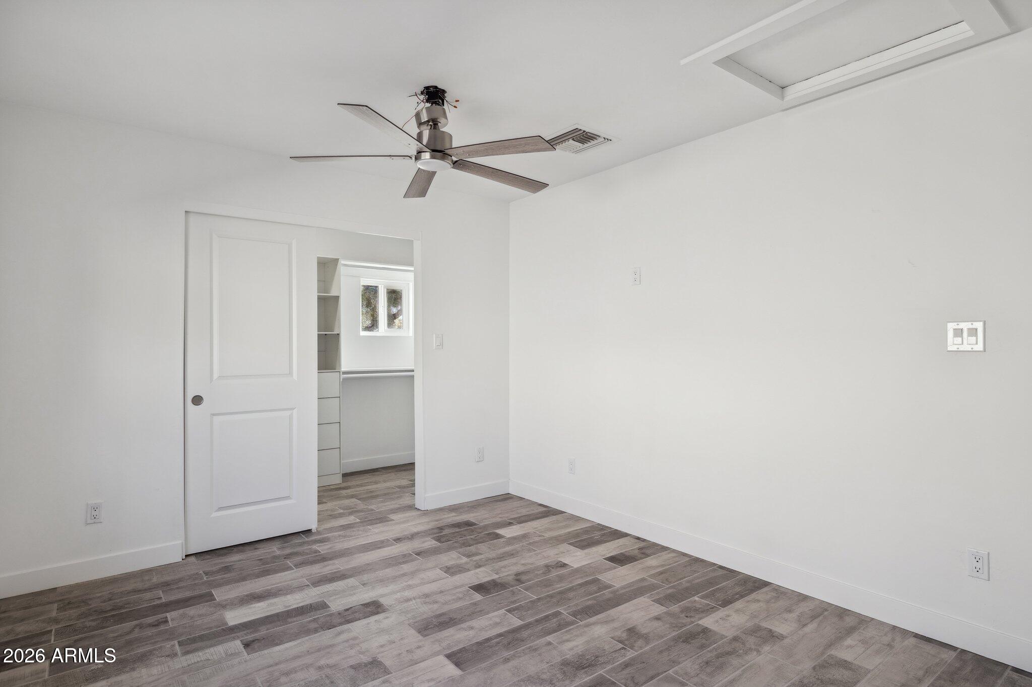 4144 North 36th Street Phoenix, AZ 85018 - Photo 11 of 30 a view of empty room with wooden floor and fan