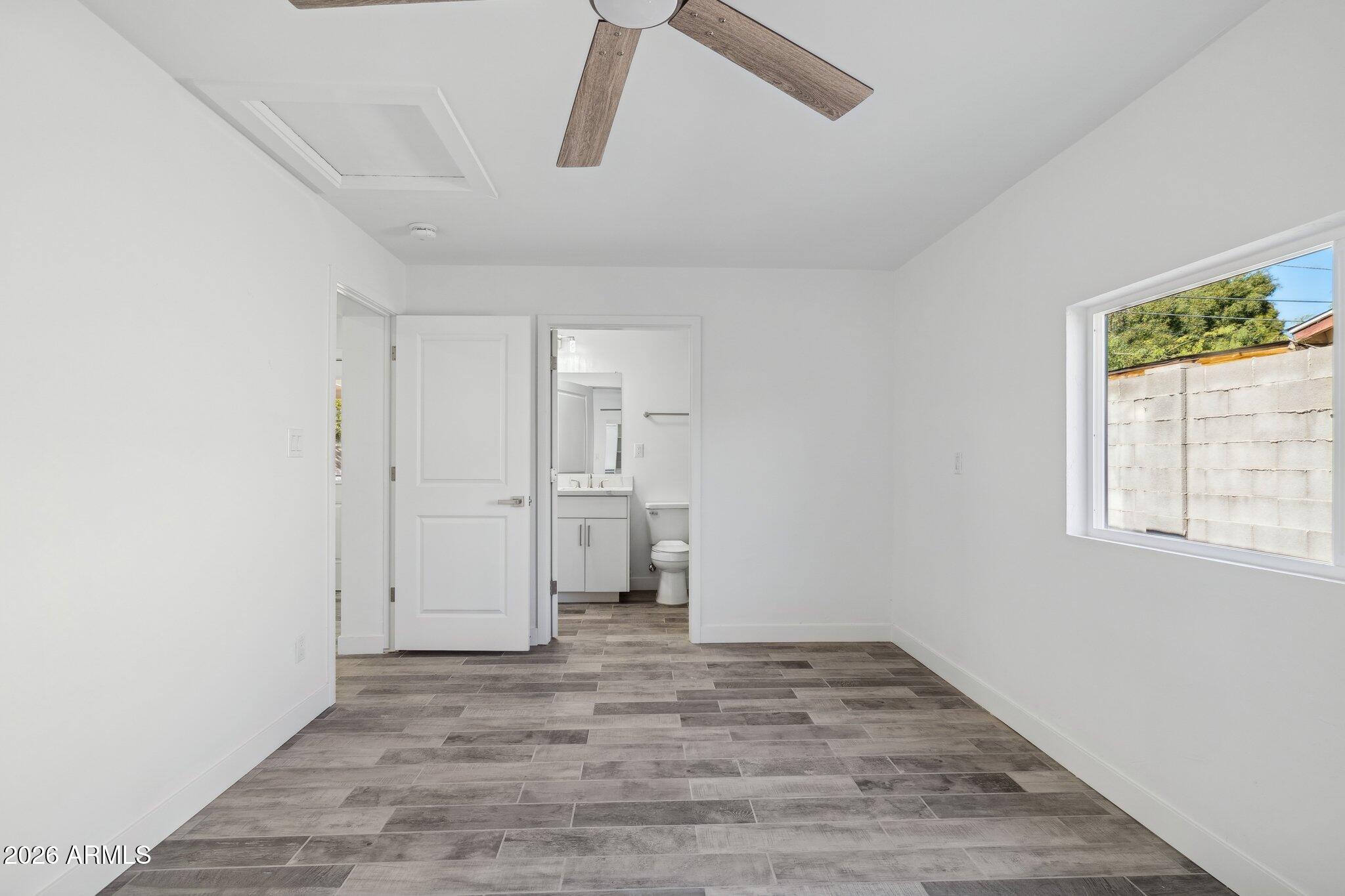 4144 North 36th Street Phoenix, AZ 85018 - Photo 12 of 30 a view of empty room with wooden floor and window
