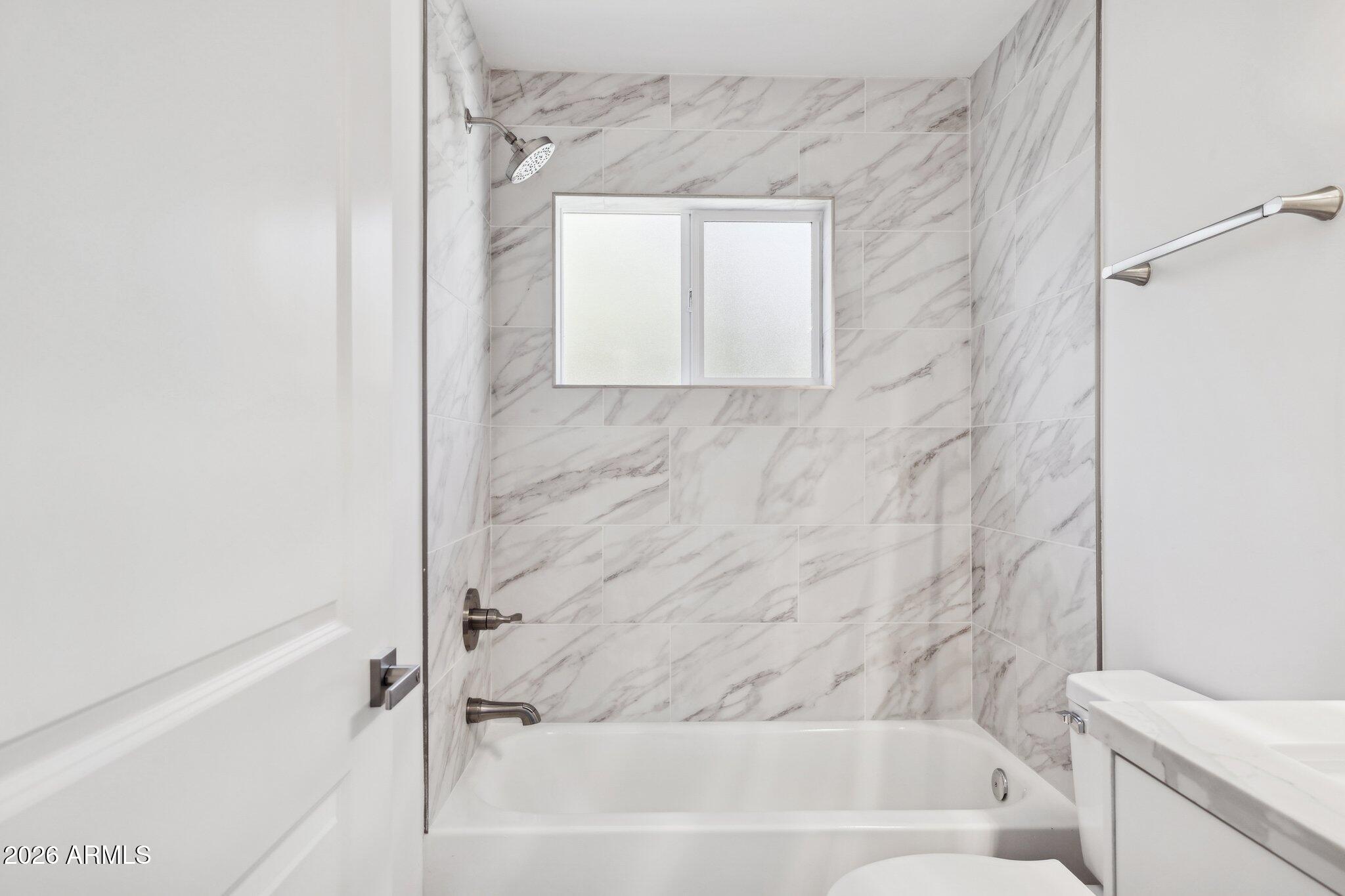4144 North 36th Street Phoenix, AZ 85018 - Photo 19 of 30 a bathroom with a bathtub and a shower