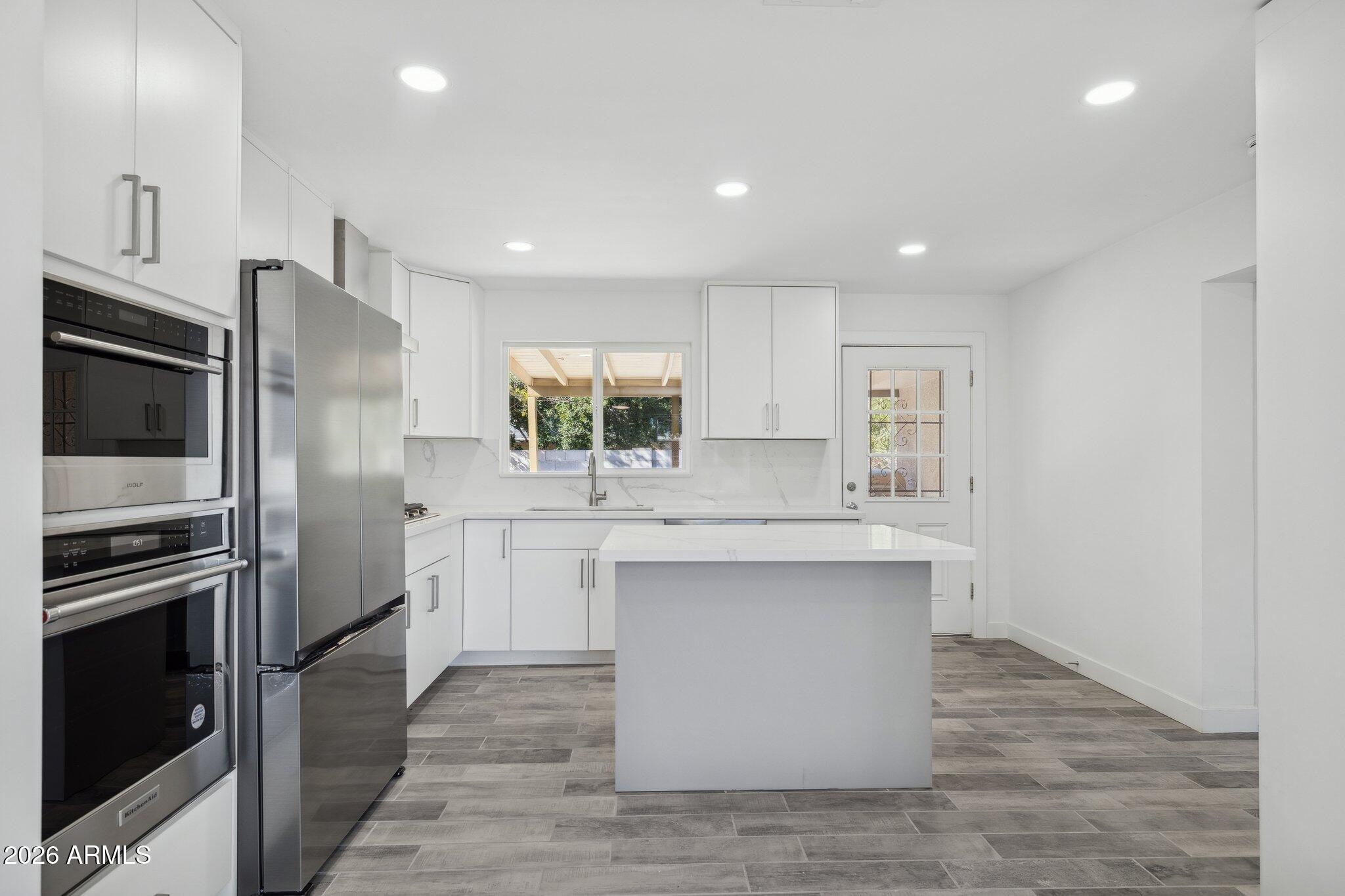 4144 North 36th Street Phoenix, AZ 85018 - Photo 3 of 30 a kitchen with white cabinets and stainless steel appliances