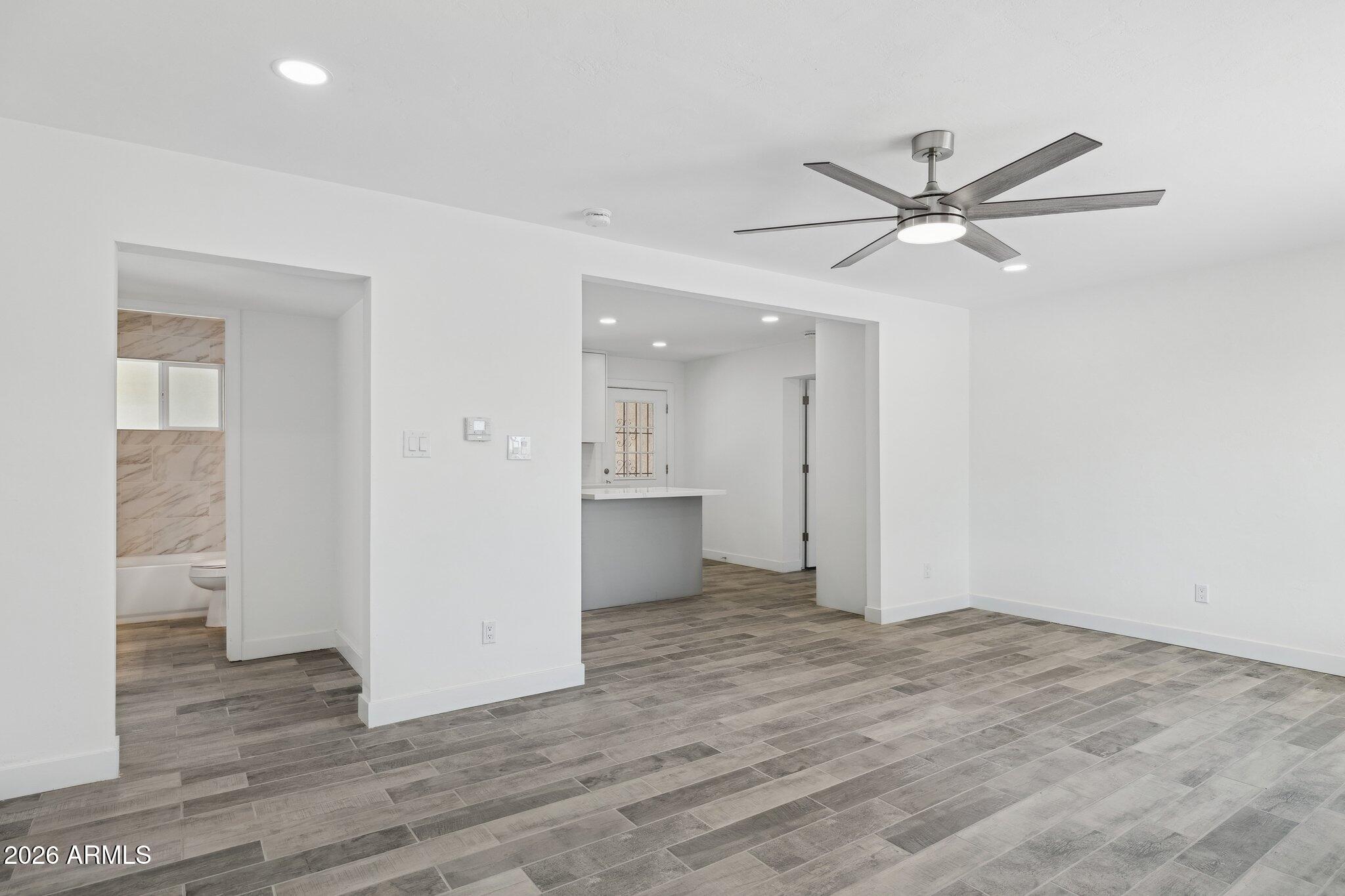 4144 North 36th Street Phoenix, AZ 85018 - Photo 8 of 30 an empty room with wooden floor and windows