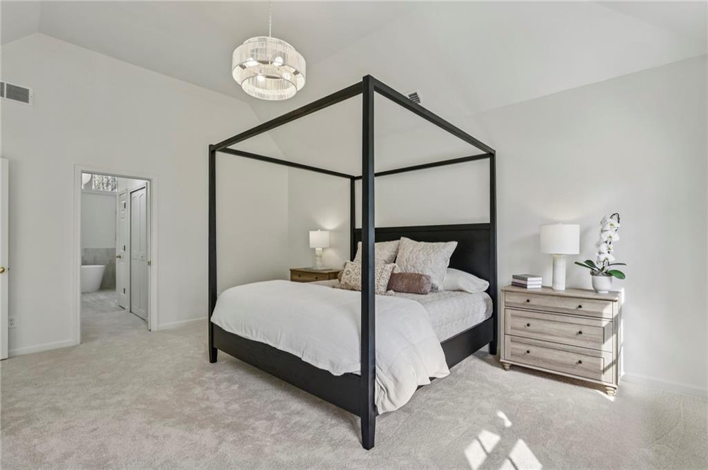 105 Inverness Approach Roswell, GA 30075 - Photo 25 of 51 a bedroom with a bed a chandelier and a closet