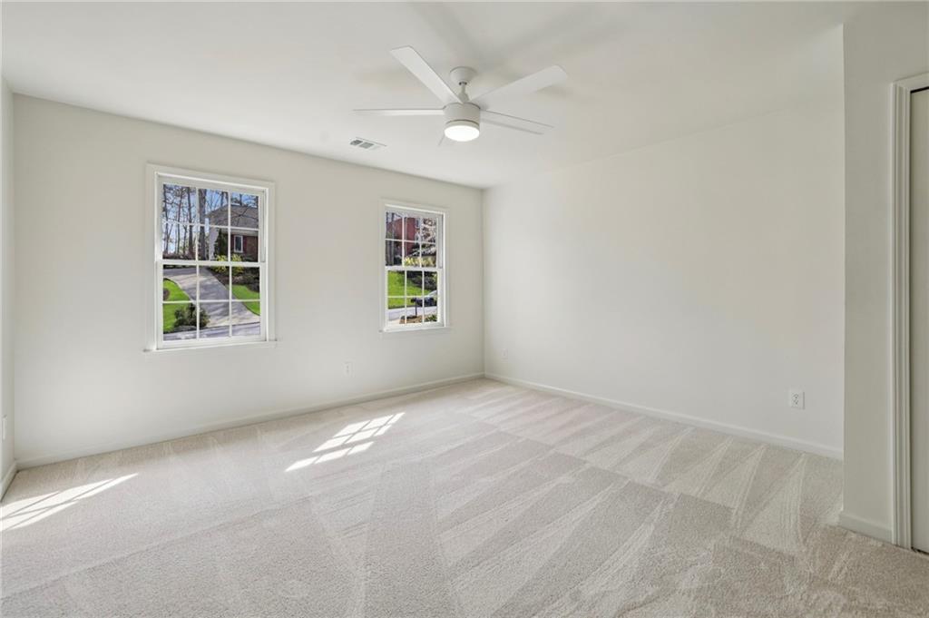 105 Inverness Approach Roswell, GA 30075 - Photo 29 of 51 an empty room with windows and ceiling fan