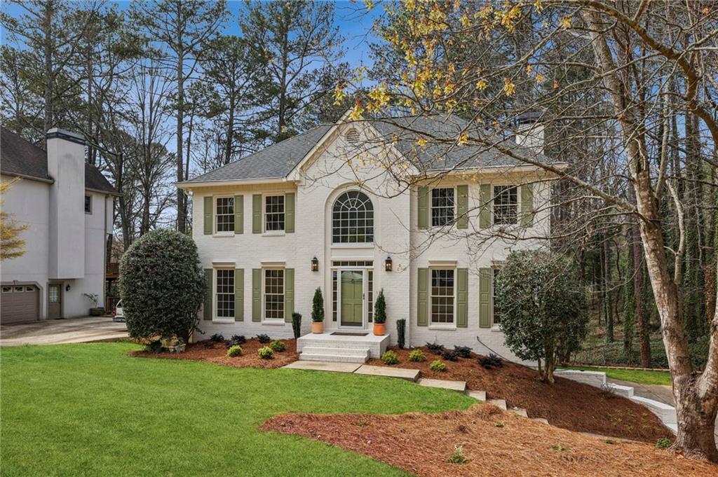 105 Inverness Approach Roswell, GA 30075 - Photo 3 of 51 a front view of a house with a garden and yard
