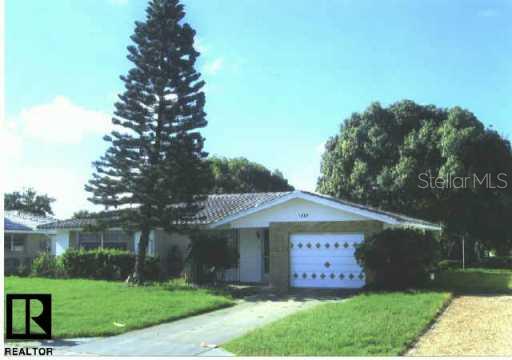 7832 Kelpie Drive Port Richey, FL 34668 - Photo 2 of 2 a view of a barn with a yard potted plants and large tree