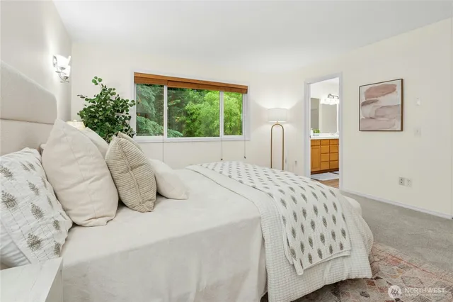 a bedroom with a bed and painting on the wall