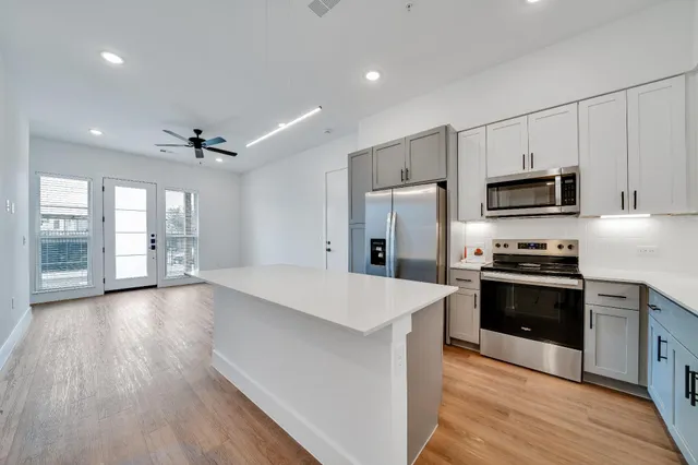 a large kitchen with stainless steel appliances granite countertop a stove and a refrigerator