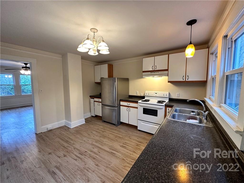 133 Lockhart Road Tryon, NC 28782 - Photo 2 of 17 a kitchen with granite countertop wooden floors stainless steel appliances and a counter space