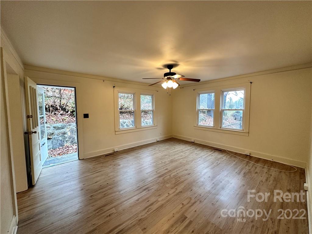 133 Lockhart Road Tryon, NC 28782 - Photo 4 of 17 a view of an empty room with a window and wooden floor
