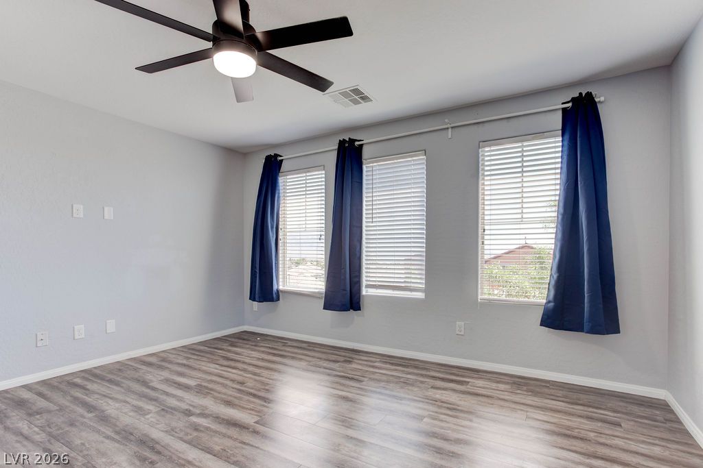 7724 Vibrant Thread Court Las Vegas, NV 89149 - Photo 23 of 43 Well-lit living area featuring rich hardwood flooring and a modern ceiling fan.