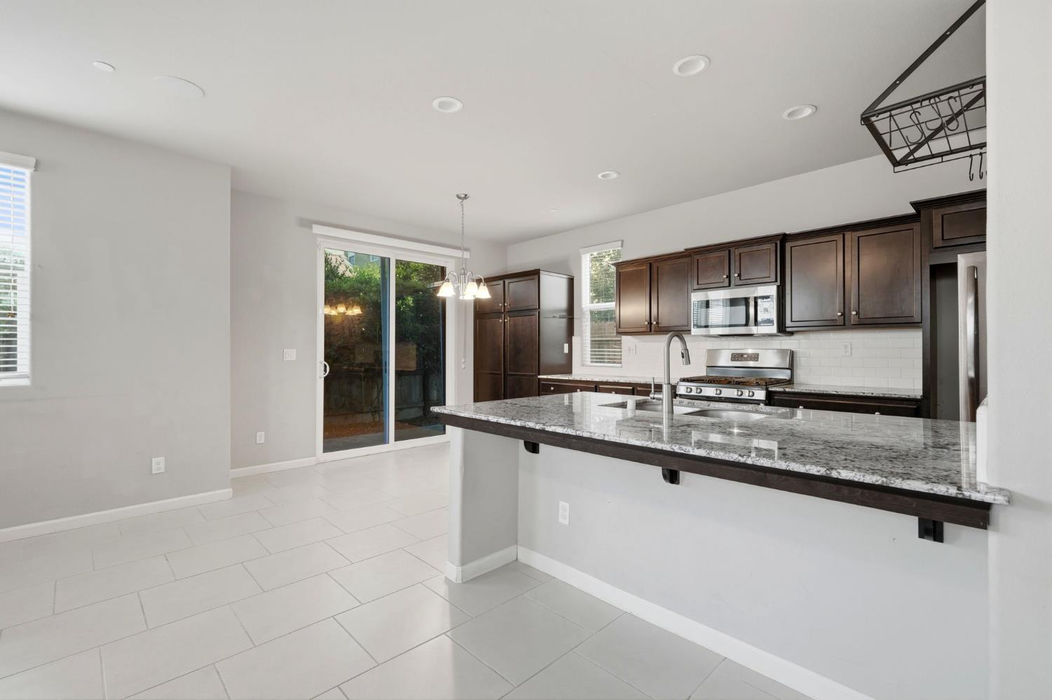 1515 Zenith Clovis, CA 93619 - Photo 13 of 41 a large white kitchen with stainless steel appliances granite countertop a sink and cabinets