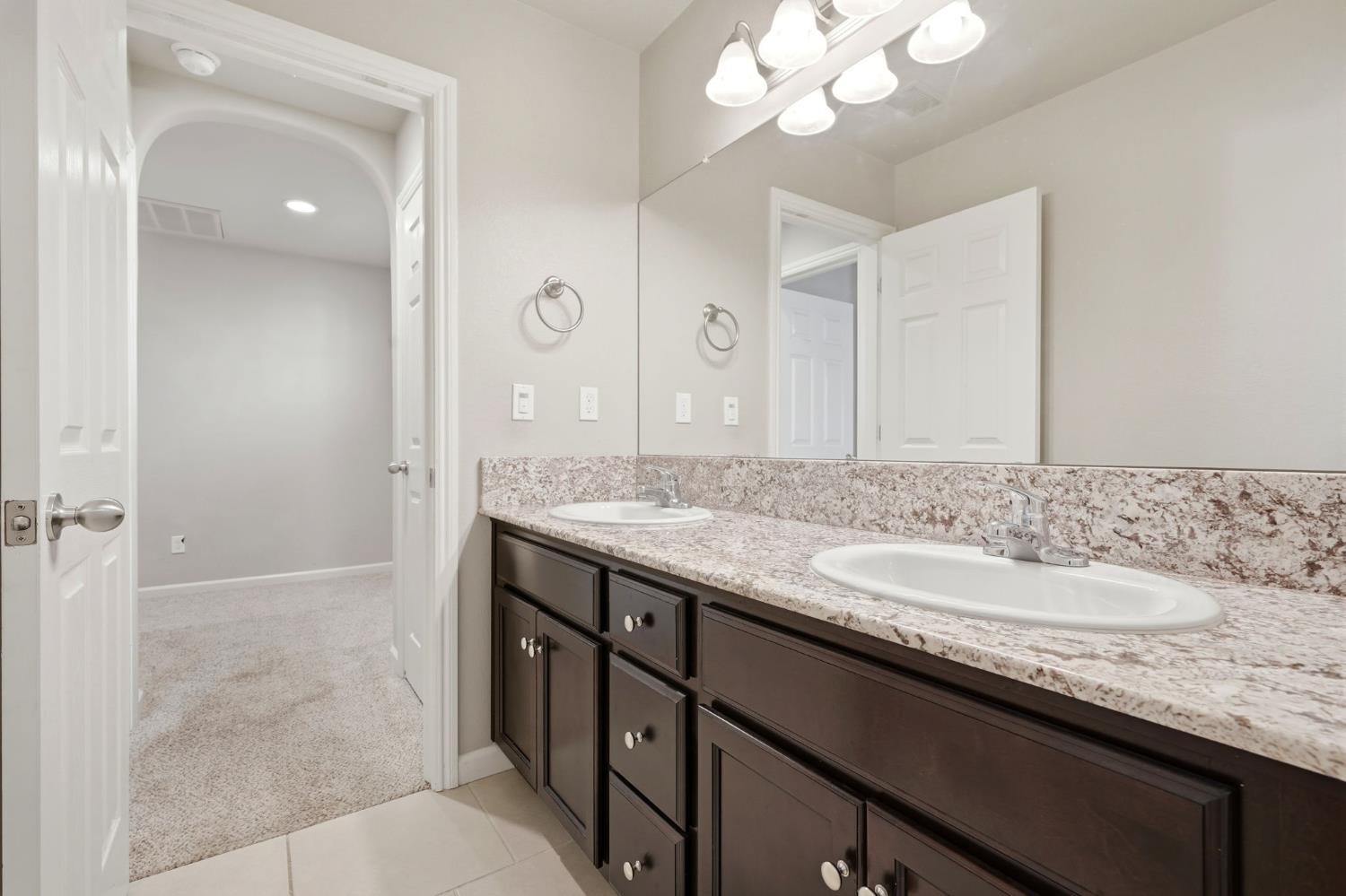 1515 Zenith Clovis, CA 93619 - Photo 29 of 41 a bathroom with a granite countertop sink a mirror and a shower