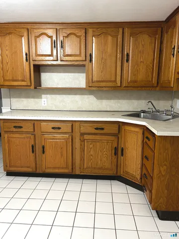 a kitchen with a sink dishwasher stove and cabinets