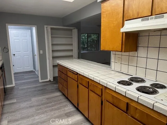 a kitchen with stainless steel appliances wooden cabinets and a stove top oven