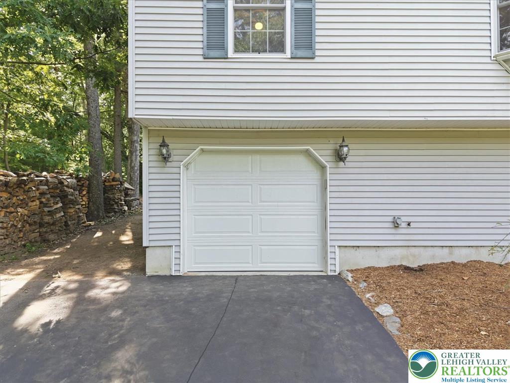 128 Chestnut Street Dingmans Ferry, PA 18328 - Photo 5 of 43 A single garage door and driveway for convenient parking.