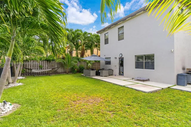 a backyard of a house with table and chairs