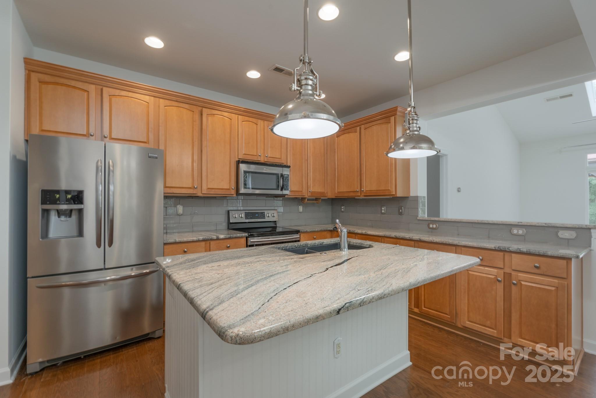 11945 Red Rust Lane Charlotte, NC 28277 - Photo 10 of 41 a kitchen with stainless steel appliances granite countertop a refrigerator a sink dishwasher a stove a dining table and chairs with wooden floor