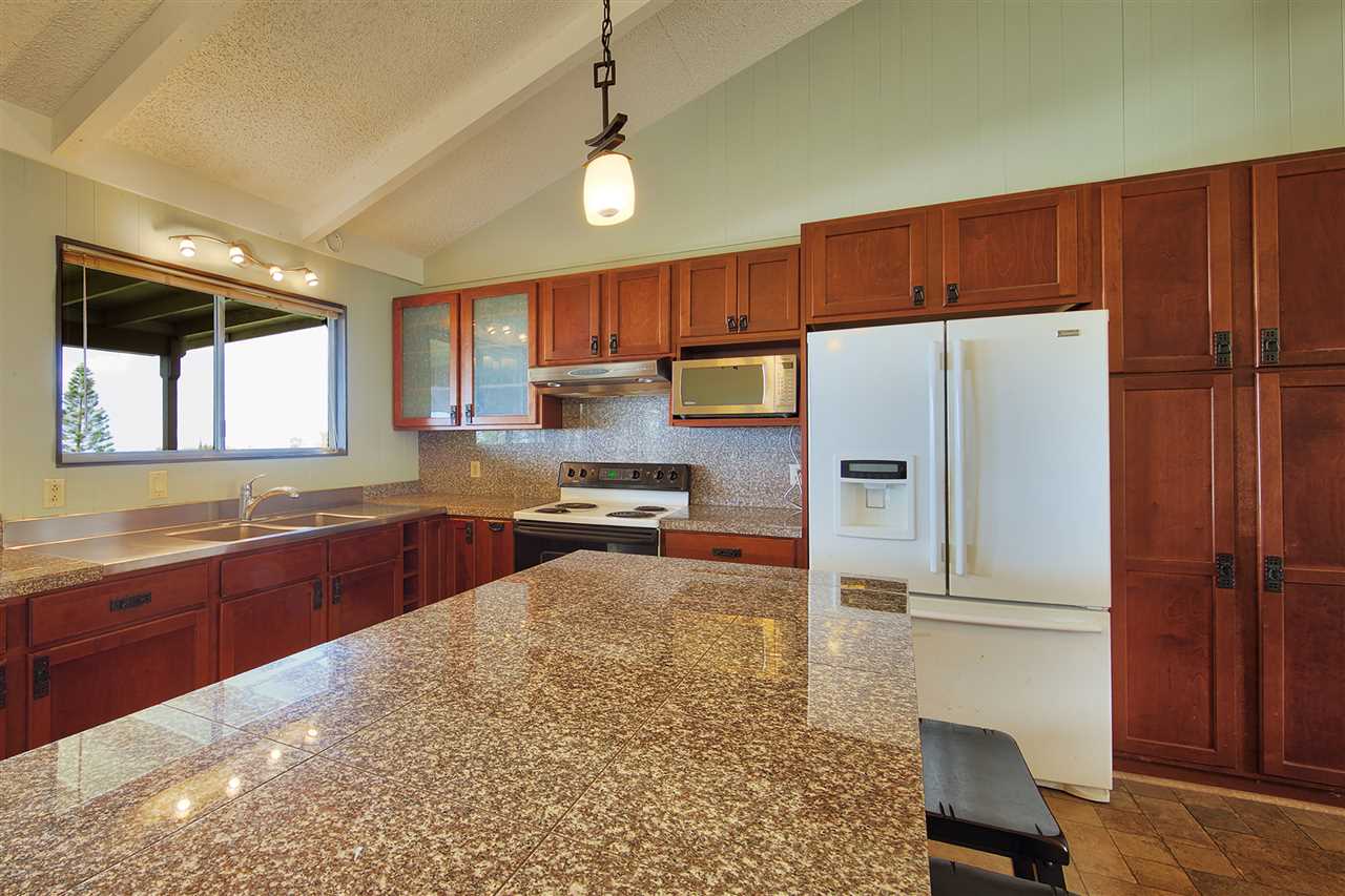 2150 Lower Kula Road Kula, HI 96790 - Photo 8 of 30 a kitchen with granite countertop a refrigerator a sink a stove a dining table and chairs