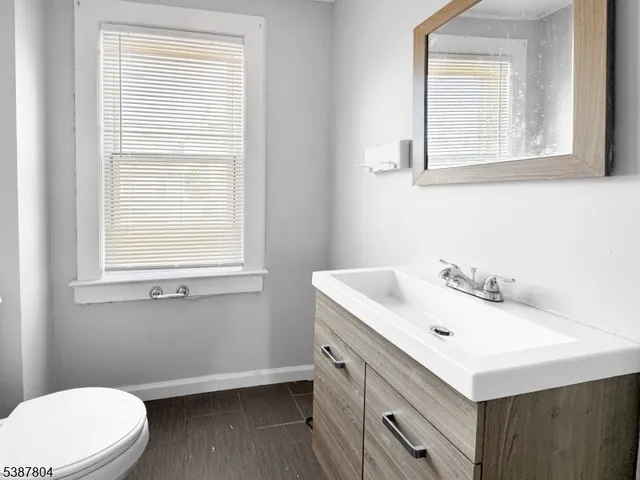 a bathroom with a sink vanity mirror and toilet