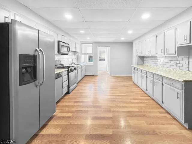 a large kitchen with kitchen island granite countertop a large counter top stainless steel appliances and cabinets