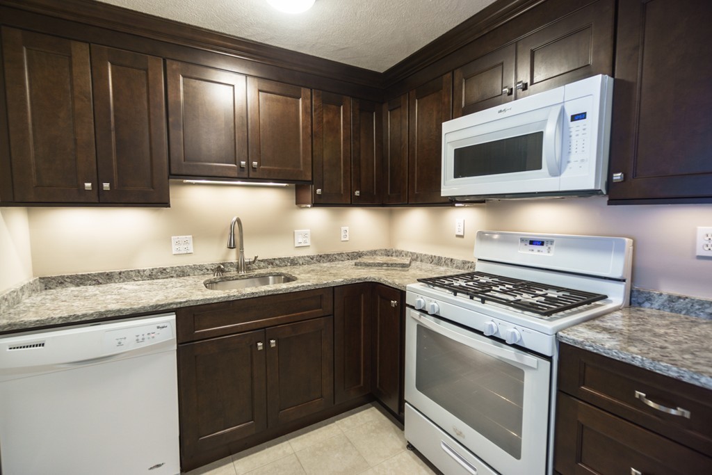 a kitchen with stainless steel appliances granite countertop a stove microwave and sink