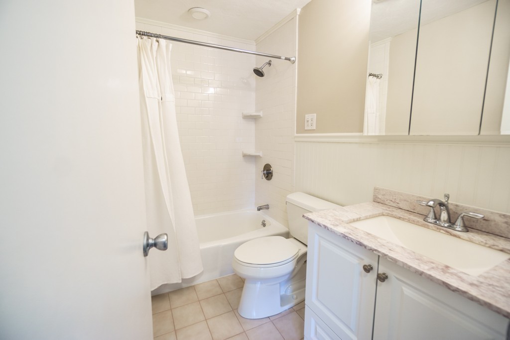 50 Colonial Drive, Unit 8 Andover, MA 01810 - Photo 17 of 25 a bathroom with a granite countertop sink a toilet and shower