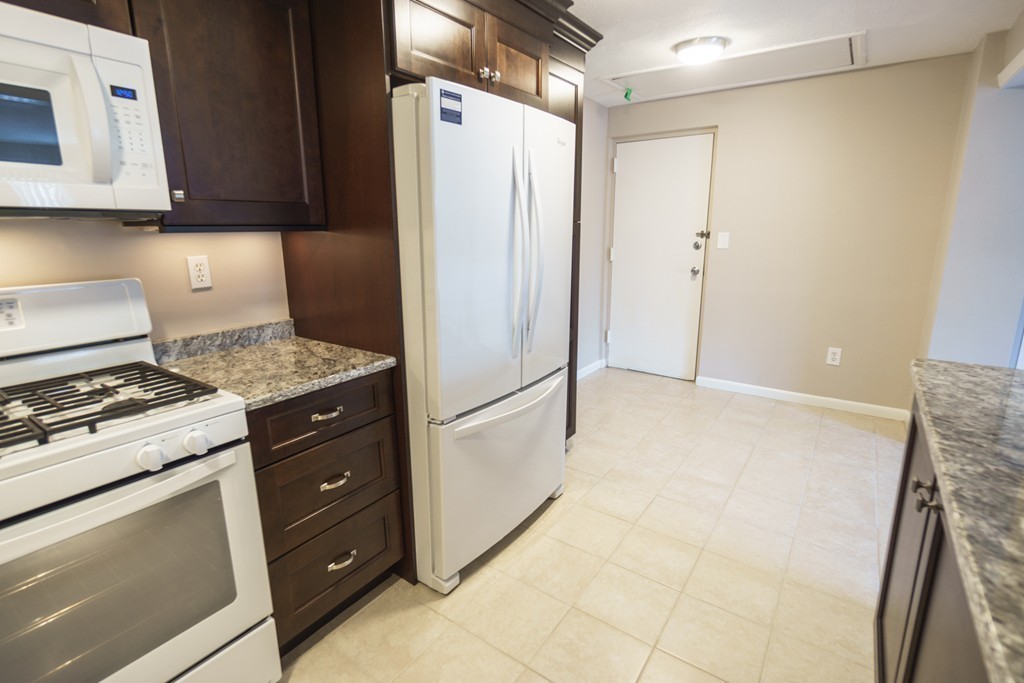 50 Colonial Drive, Unit 8 Andover, MA 01810 - Photo 2 of 25 a kitchen with a refrigerator and a stove top oven