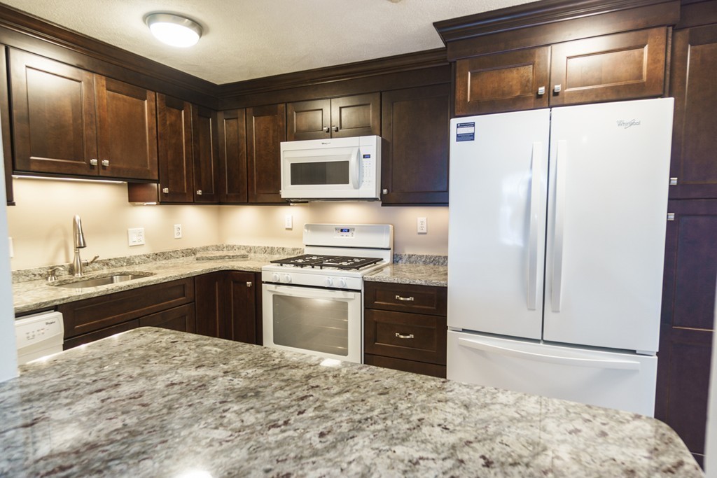 50 Colonial Drive, Unit 8 Andover, MA 01810 - Photo 5 of 25 a kitchen with granite countertop a refrigerator and a stove top oven