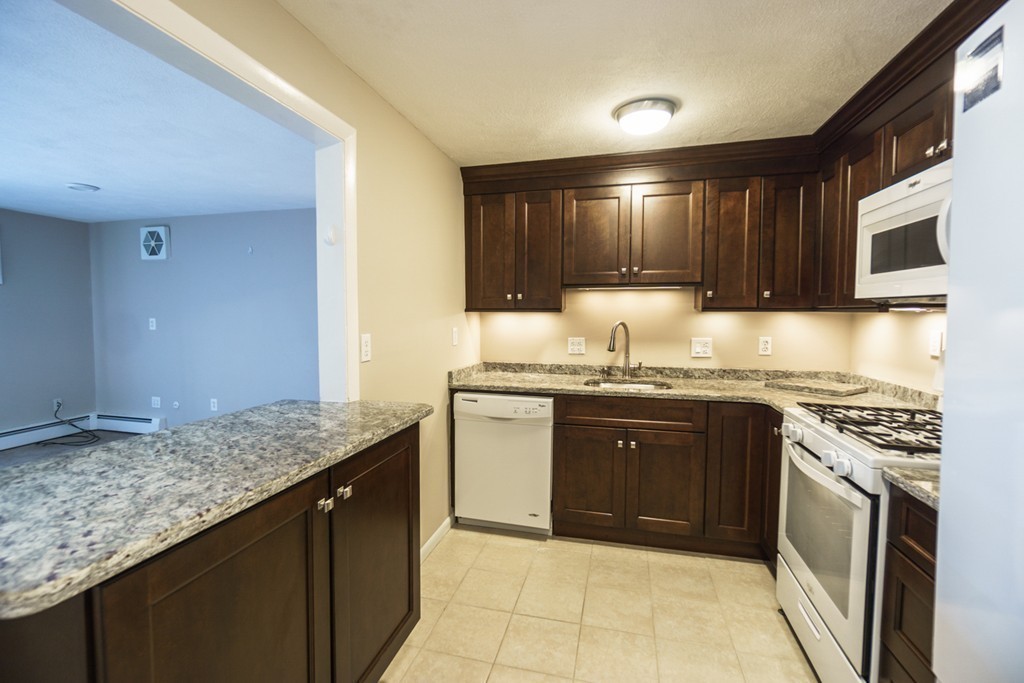 50 Colonial Drive, Unit 8 Andover, MA 01810 - Photo 6 of 25 a kitchen with granite countertop a sink and cabinets