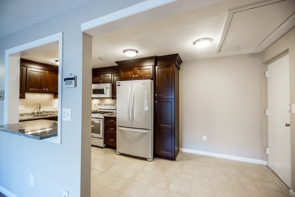 50 Colonial Drive, Unit 8 Andover, MA 01810 - Photo 8 of 25 a kitchen with stainless steel appliances a refrigerator and a stove top oven