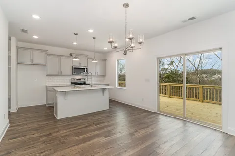 a kitchen with a sink a microwave a stove and cabinets