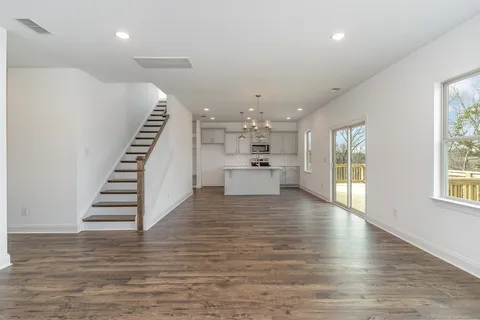 a kitchen with kitchen island a sink stainless steel appliances and wooden floor