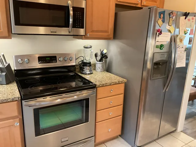 a kitchen with stainless steel appliances granite countertop a refrigerator stove and microwave