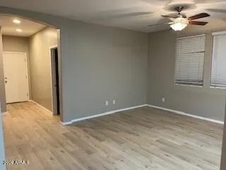 an empty room with windows and fan