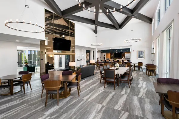 a living room with furniture kitchen view and a large window