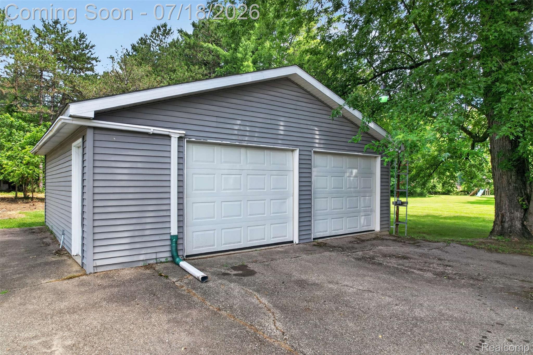 1437 East Cook Road Grand Blanc, MI 48439 - Photo 7 of 69 Detached two-car garage with gray horizontal siding, white panel garage doors, and a side entry door