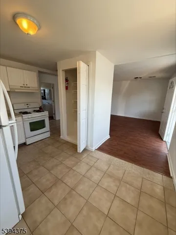 a view of a kitchen with furniture and an empty room