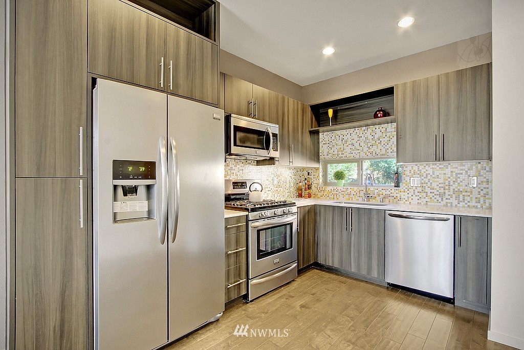 300 26th Avenue South, Unit B Seattle, WA 98144 - Photo 7 of 13 a kitchen with granite countertop stainless steel appliances and wooden cabinets