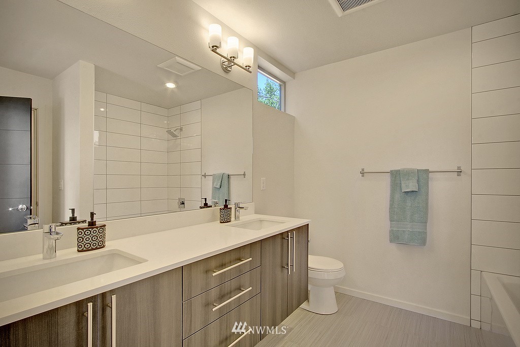 300 26th Avenue South, Unit B Seattle, WA 98144 - Photo 10 of 13 a bathroom with a double vanity sink a toilet and a mirror