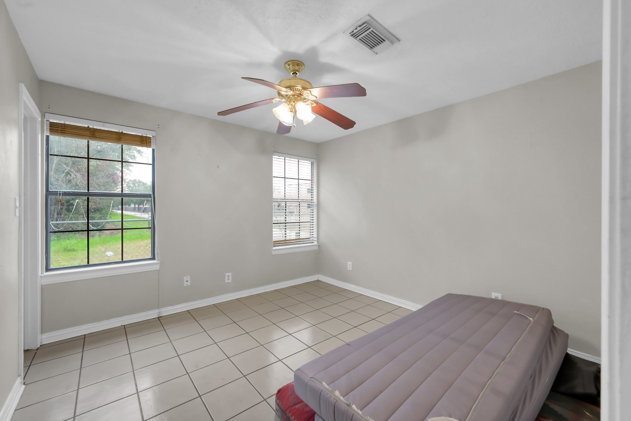 7644 Spring Cypress Road Spring, TX 77379 - Photo 19 of 28 an empty room with windows and fan