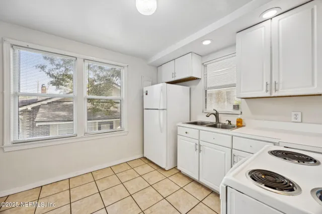 a kitchen with white cabinets and white appliances