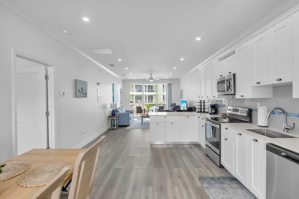 a kitchen with granite countertop a sink stainless steel appliances and cabinets