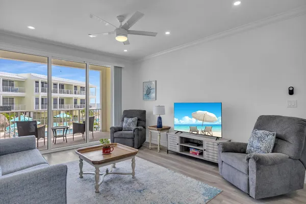 a living room with furniture a flat screen tv and a floor to ceiling window